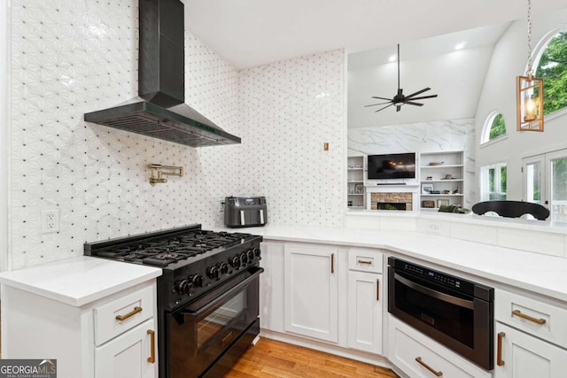 5535 Buck Hollow Dr, Alpharetta, GA 30005 - kitchen with wall chimney range hood, high end stove, open floor plan, ceiling fan, and white cabinets