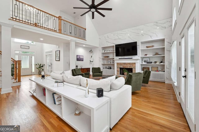 5535 Buck Hollow Dr, Alpharetta, GA 30005 - living area featuring high vaulted ceiling, stairs, a ceiling fan, a fireplace, and built in shelves