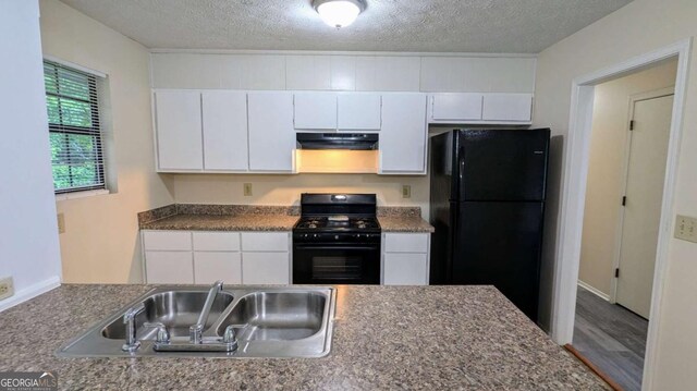 2168 Sara Ashley Way, Lithonia, GA 30058 - kitchen featuring range with gas cooktop, freestanding refrigerator, under cabinet range hood, white cabinetry, and a textured ceiling
