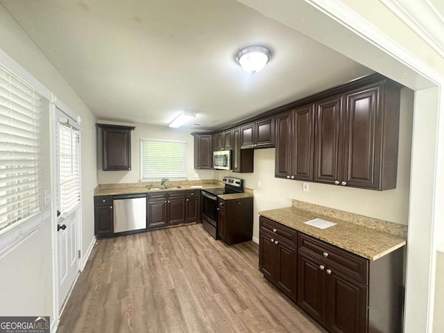 2469 Baywood Dr SE, Atlanta, GA 30315 - kitchen featuring appliances with stainless steel finishes, light wood-style flooring, dark brown cabinetry, and a sink