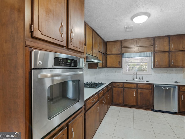 1001 Stagecoach Rd, Stockbridge, GA 30281 - kitchen with stainless steel appliances, a sink, under cabinet range hood, a textured ceiling, and backsplash