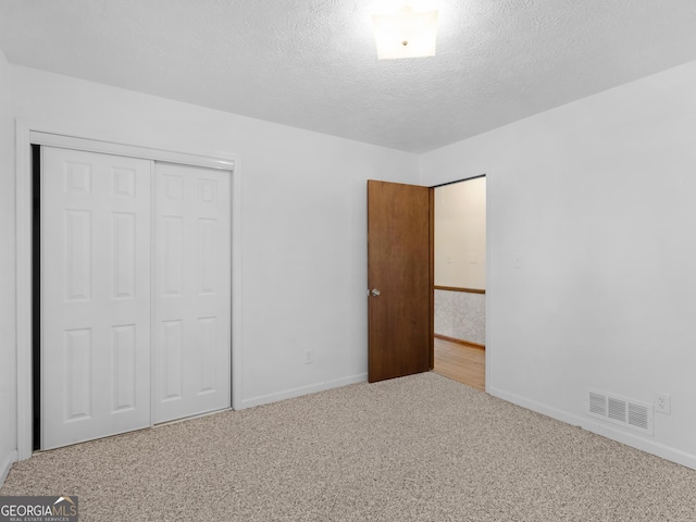 1001 Stagecoach Rd, Stockbridge, GA 30281 - unfurnished bedroom featuring carpet flooring, baseboards, a closet, and a textured ceiling