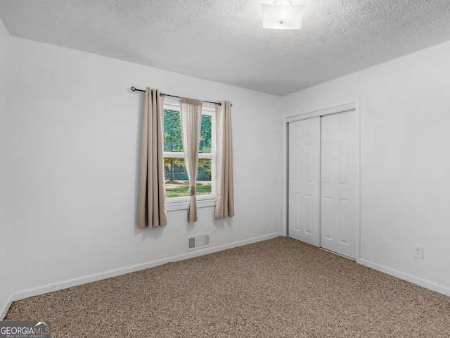1001 Stagecoach Rd, Stockbridge, GA 30281 - unfurnished bedroom featuring carpet, a textured ceiling, baseboards, and a closet