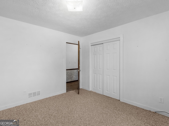 1001 Stagecoach Rd, Stockbridge, GA 30281 - unfurnished bedroom featuring carpet, a closet, a textured ceiling, and baseboards