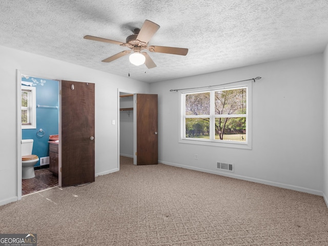1001 Stagecoach Rd, Stockbridge, GA 30281 - unfurnished bedroom with multiple windows, a textured ceiling, baseboards, carpet, and ensuite bathroom