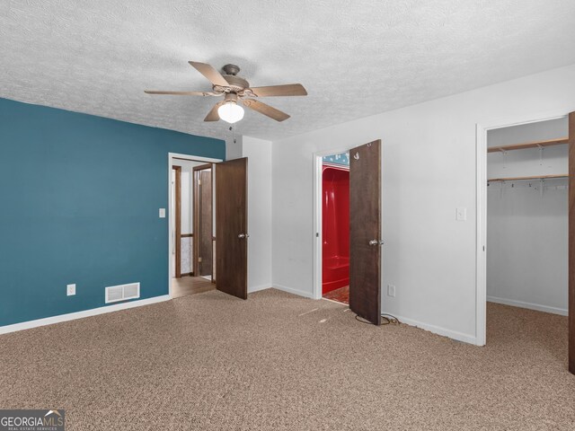 1001 Stagecoach Rd, Stockbridge, GA 30281 - unfurnished bedroom with carpet floors, a spacious closet, baseboards, a textured ceiling, and a closet