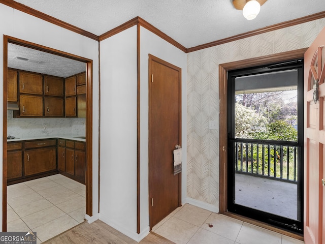 1001 Stagecoach Rd, Stockbridge, GA 30281 - entryway with ornamental molding, wallpapered walls, a textured ceiling, baseboards, and light tile patterned flooring