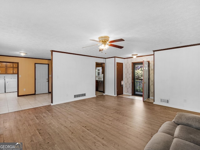 1001 Stagecoach Rd, Stockbridge, GA 30281 - living room featuring washer and clothes dryer, ceiling fan, light wood-type flooring, crown molding, and baseboards