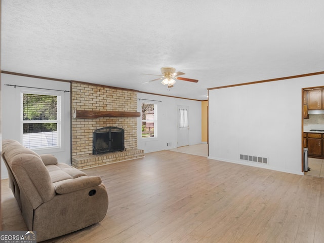 1001 Stagecoach Rd, Stockbridge, GA 30281 - living area featuring light wood finished floors, a ceiling fan, ornamental molding, a brick fireplace, and baseboards