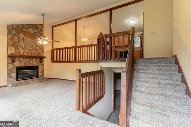 3440 Quinn Ridge Dr, Snellville, GA 30039 - stairway with ceiling fan, carpet, a stone fireplace, and high vaulted ceiling