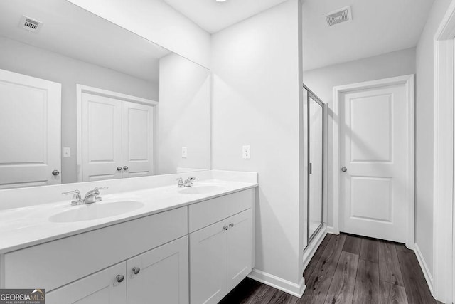 1998 Nuthatch Dr, Hoschton, GA 30548 - full bathroom featuring double vanity, wood finished floors, baseboards, and a stall shower