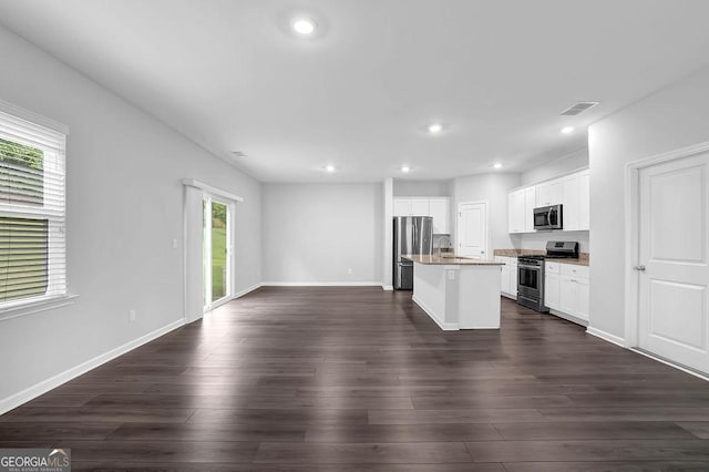 1998 Nuthatch Dr, Hoschton, GA 30548 - kitchen with appliances with stainless steel finishes, an island with sink, baseboards, open floor plan, and recessed lighting