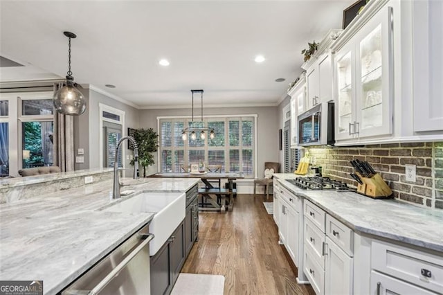 3665 Pennington Rd, Cumming, GA 30041 - kitchen with appliances with stainless steel finishes, white cabinets, dark wood-style flooring, light stone counters, and ornamental molding