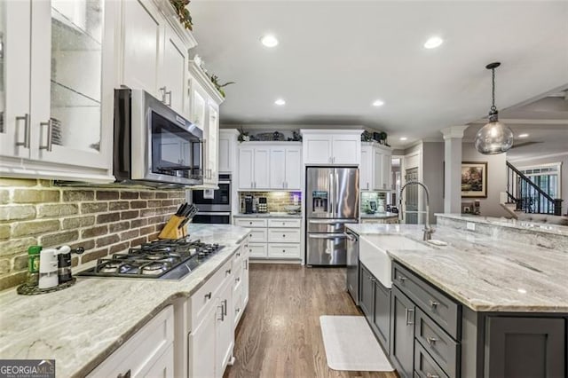 3665 Pennington Rd, Cumming, GA 30041 - kitchen with appliances with stainless steel finishes, white cabinets, tasteful backsplash, light stone counters, and pendant lighting