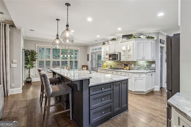 3665 Pennington Rd, Cumming, GA 30041 - kitchen with stainless steel appliances, white cabinetry, crown molding, dark wood-type flooring, and backsplash