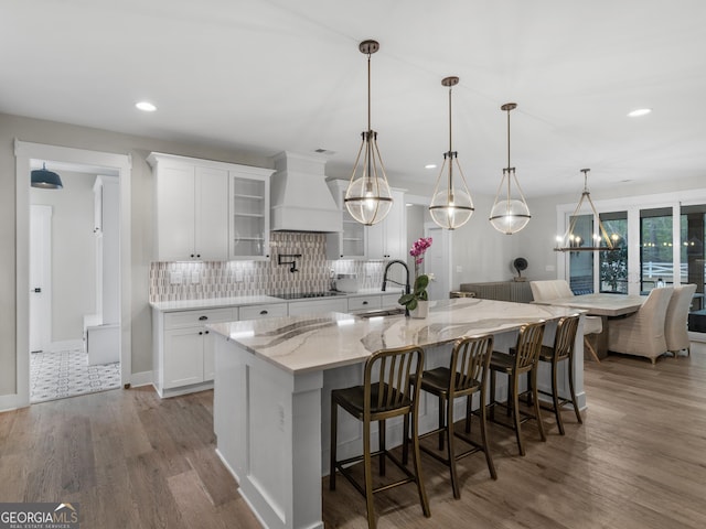319 S Mount Carmel Rd, Mcdonough, GA 30253 - kitchen with custom range hood, white cabinets, wood finished floors, backsplash, and recessed lighting