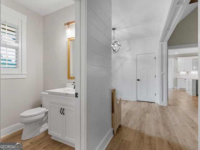 319 S Mount Carmel Rd, Mcdonough, GA 30253 - bathroom featuring wood finished floors, vanity, toilet, backsplash, and baseboards