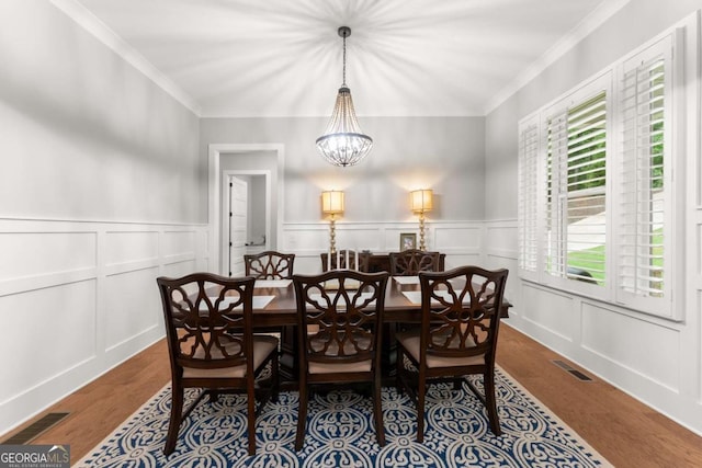 4847 Destitute Way, Gainesville, GA 30506 - dining area with a decorative wall, a chandelier, crown molding, wood finished floors, and wainscoting