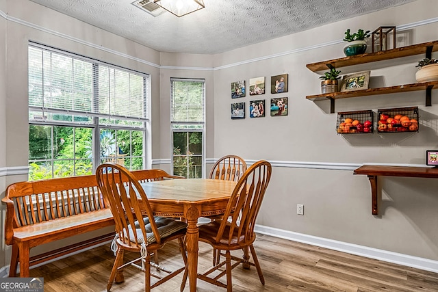 161 Mills Dr, Covington, GA 30016 - dining space featuring wood finished floors, a textured ceiling, and baseboards
