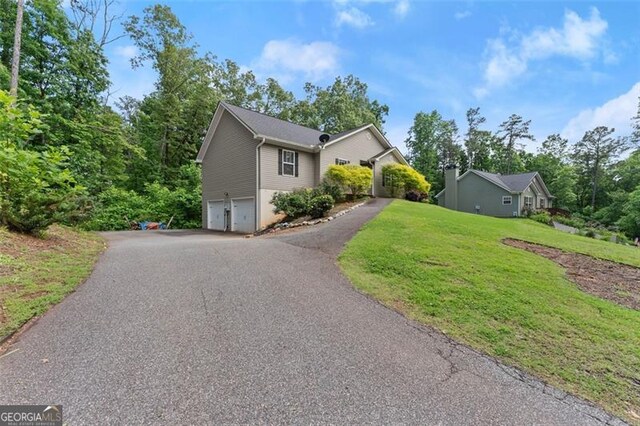 15 Baker St, Dahlonega, GA 30533 - view of side of property featuring a garage, asphalt driveway, and a yard