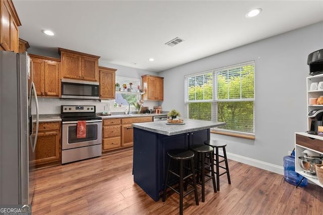 15 Baker St, Dahlonega, GA 30533 - kitchen with stainless steel appliances, brown cabinets, a center island, wood finished floors, and light countertops