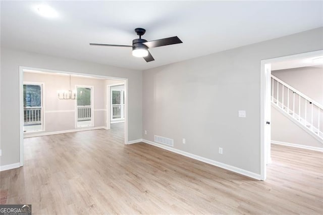 4806 Deer Chase, Powder Springs, GA 30127 - spare room featuring a ceiling fan, a chandelier, stairs, light wood finished floors, and baseboards