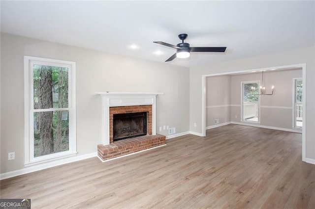 4806 Deer Chase, Powder Springs, GA 30127 - unfurnished living room with wood finished floors, a brick fireplace, a chandelier, and baseboards