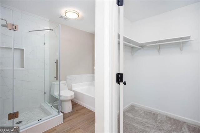 4806 Deer Chase, Powder Springs, GA 30127 - full bathroom with a stall shower, a walk in closet, a bath, toilet, and wood finished floors