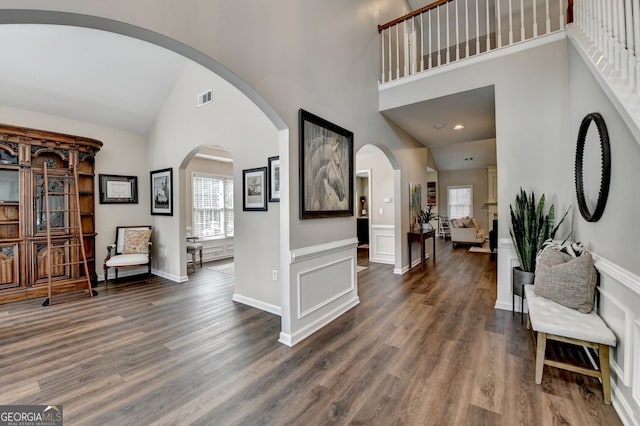 2633 Hanriva Ct, Dacula, GA 30019 - entrance foyer with high vaulted ceiling, dark wood-style flooring, arched walkways, and baseboards