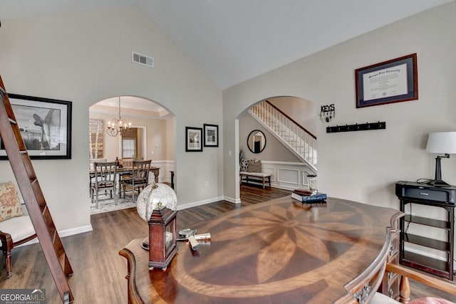 2633 Hanriva Ct, Dacula, GA 30019 - dining room featuring arched walkways, high vaulted ceiling, dark wood-style floors, a chandelier, and stairway