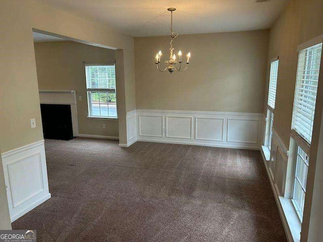 3140 Tylerton Dr SW, Atlanta, GA 30311 - unfurnished dining area featuring a chandelier, a wainscoted wall, a decorative wall, a fireplace with flush hearth, and carpet floors