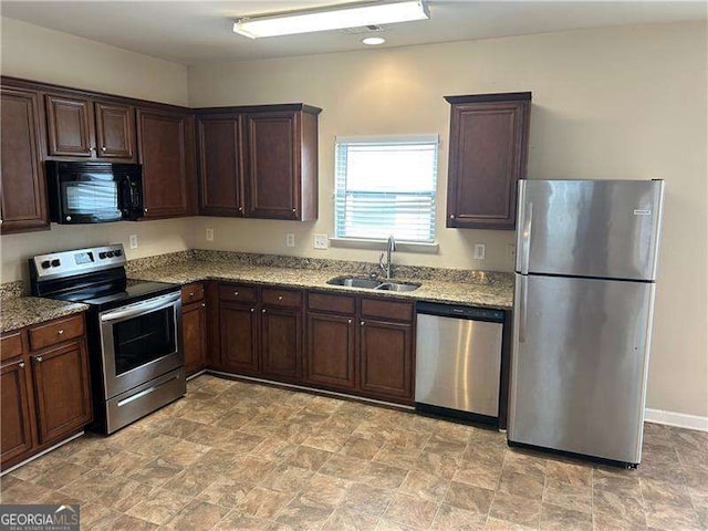3140 Tylerton Dr SW, Atlanta, GA 30311 - kitchen with appliances with stainless steel finishes, light stone counters, and dark brown cabinets