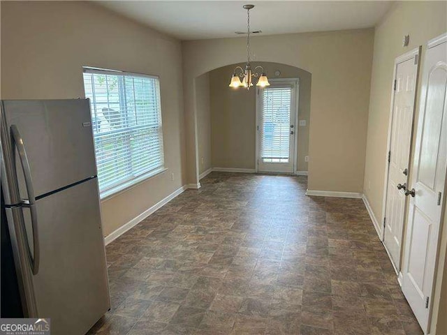 3140 Tylerton Dr SW, Atlanta, GA 30311 - unfurnished dining area featuring a chandelier, arched walkways, and stone finish floors