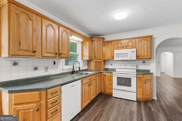 2644 Hickory Valley Dr, Snellville, GA 30078 - kitchen with white appliances, arched walkways, dark wood-style floors, dark countertops, and ornamental molding
