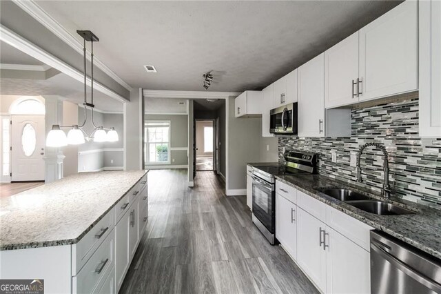 4820 Camden Dr SW, Conyers, GA 30094 - kitchen with appliances with stainless steel finishes, a sink, decorative backsplash, stone countertops, and wood finished floors