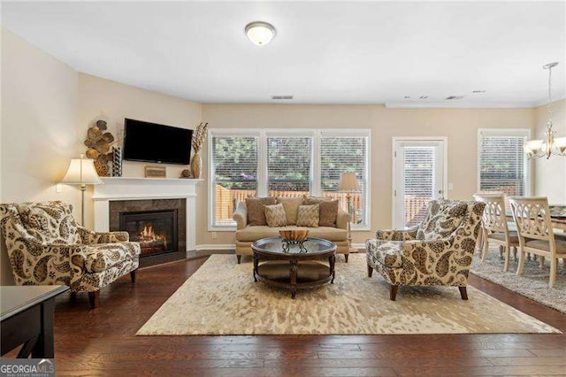 6160 Shiloh Woods Dr, Cumming, GA 30040 - living area featuring dark wood-style floors, a chandelier, a fireplace with flush hearth, plenty of natural light, and crown molding