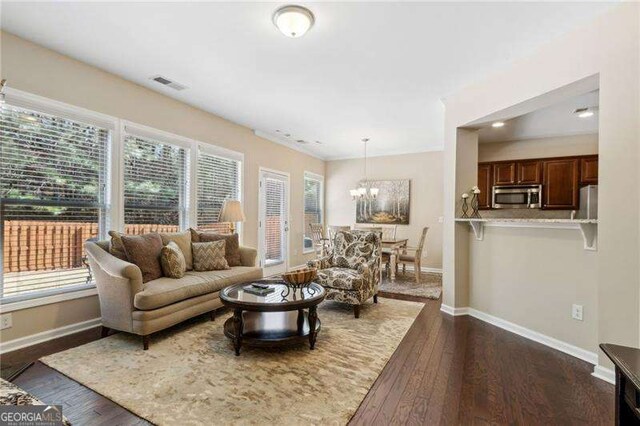 6160 Shiloh Woods Dr, Cumming, GA 30040 - living room with baseboards, dark wood-style floors, and a chandelier