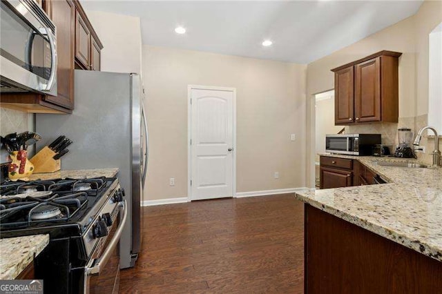 6160 Shiloh Woods Dr, Cumming, GA 30040 - kitchen featuring stainless steel appliances, a sink, light stone countertops, baseboards, and dark wood-style floors