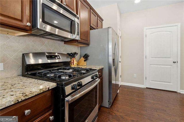 6160 Shiloh Woods Dr, Cumming, GA 30040 - kitchen with stainless steel appliances, light stone countertops, backsplash, and dark wood-style floors