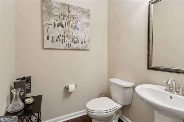 6160 Shiloh Woods Dr, Cumming, GA 30040 - half bathroom with toilet, baseboards, a sink, and wood finished floors
