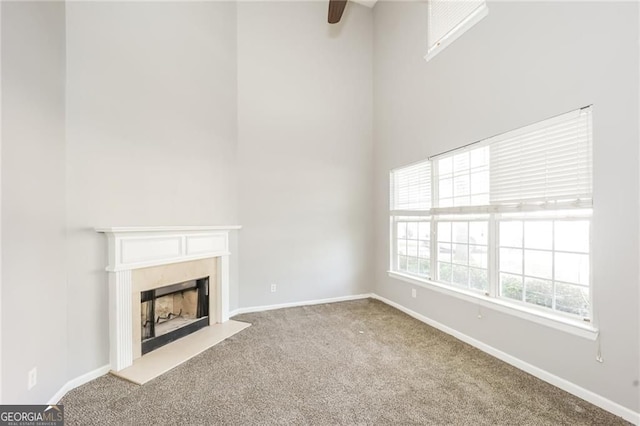 6073 Camden Forrest Dr, Riverdale, GA 30296 - unfurnished living room with carpet, a fireplace, a ceiling fan, and a towering ceiling
