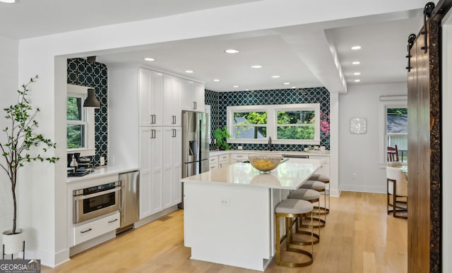 1168 Mclynn Ave NE, Atlanta, GA 30306 - kitchen featuring stainless steel appliances, a breakfast bar, white cabinets, light countertops, and recessed lighting