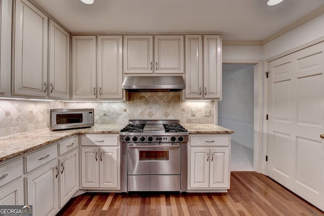 5507 Martina Way, Dunwoody, GA 30338 - kitchen with stainless steel range with gas cooktop, ventilation hood, light wood finished floors, tasteful backsplash, and crown molding
