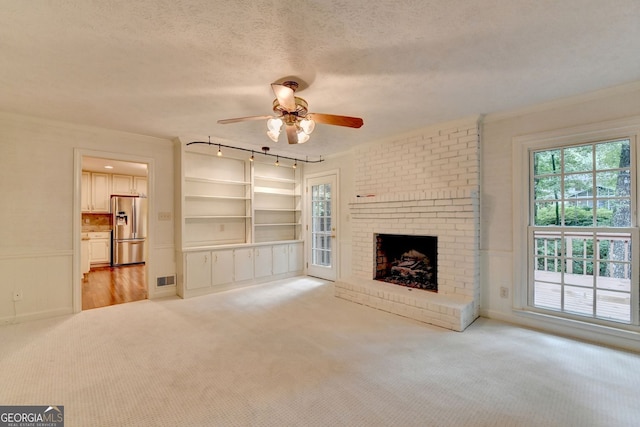 5507 Martina Way, Dunwoody, GA 30338 - unfurnished living room featuring ornamental molding, a ceiling fan, plenty of natural light, light colored carpet, and a textured ceiling