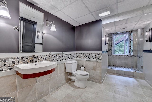 5507 Martina Way, Dunwoody, GA 30338 - full bathroom featuring a shower stall, toilet, tile patterned flooring, a paneled ceiling, and tile walls