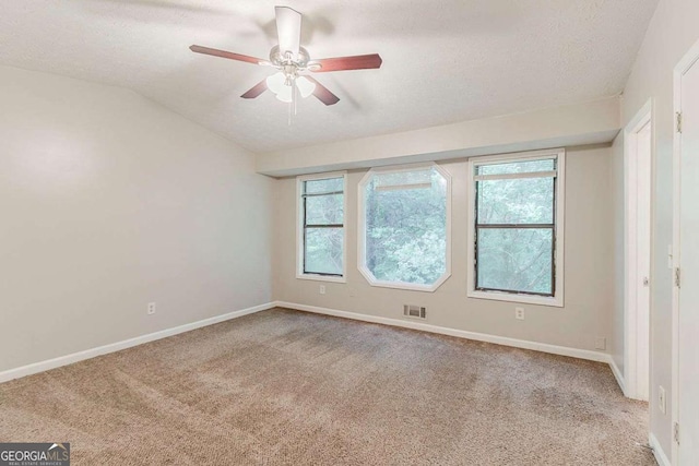 2218 Lowtrail Ct, Lithonia, GA 30058 - empty room with carpet flooring, a textured ceiling, ceiling fan, healthy amount of natural light, and baseboards