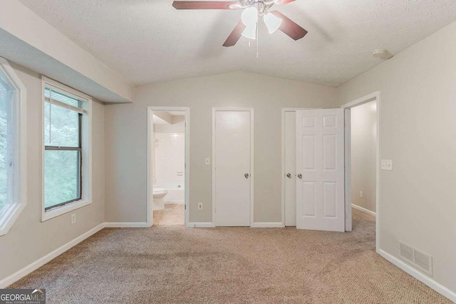 2218 Lowtrail Ct, Lithonia, GA 30058 - unfurnished bedroom with multiple windows, carpet flooring, vaulted ceiling, baseboards, and ensuite bathroom
