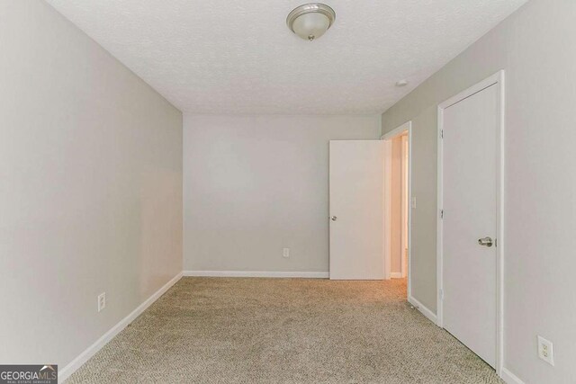 2218 Lowtrail Ct, Lithonia, GA 30058 - carpeted spare room featuring a textured ceiling and baseboards