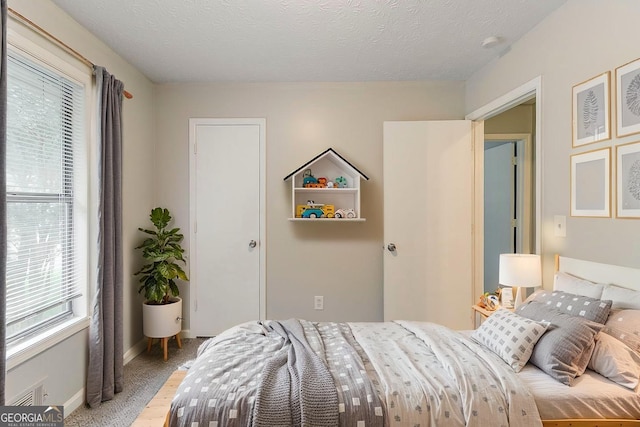 2218 Lowtrail Ct, Lithonia, GA 30058 - bedroom featuring multiple windows, baseboards, a textured ceiling, and wood finished floors