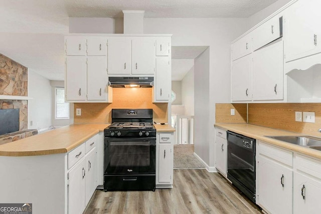 2218 Lowtrail Ct, Lithonia, GA 30058 - kitchen featuring black appliances, under cabinet range hood, light wood-style floors, white cabinetry, and a peninsula
